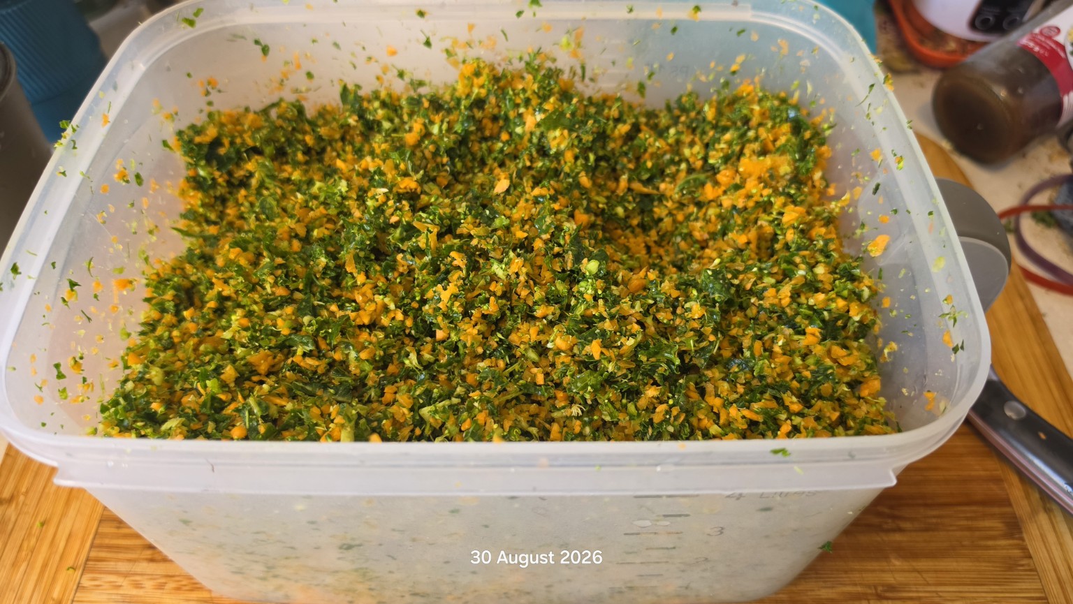 A large container of finished carrot, broccoli, kale and dill chop